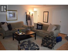 A living room with a couch, coffee table, and two pictures on the wall.