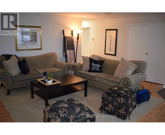 A living room with a couch, coffee table, and two pictures on the wall.