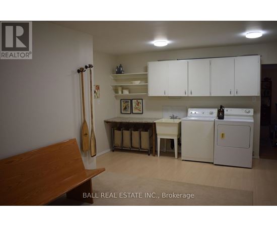 A kitchen with white cabinets and a wooden bench.