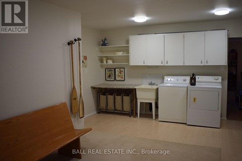 A kitchen with white cabinets and a wooden bench.