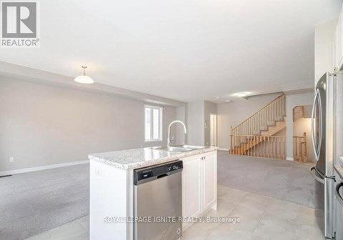 A kitchen with white appliances and a marble countertop.