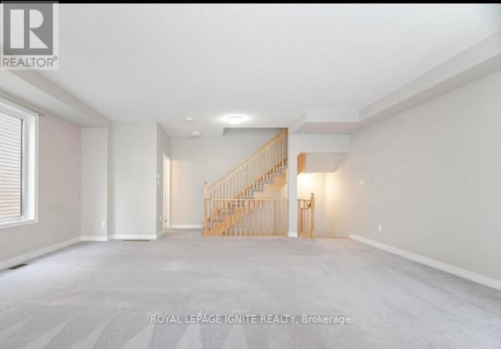 A spacious room with a staircase in the middle.