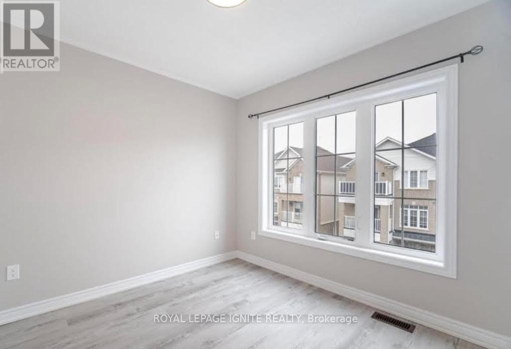A room with a large window showing a view of other buildings.