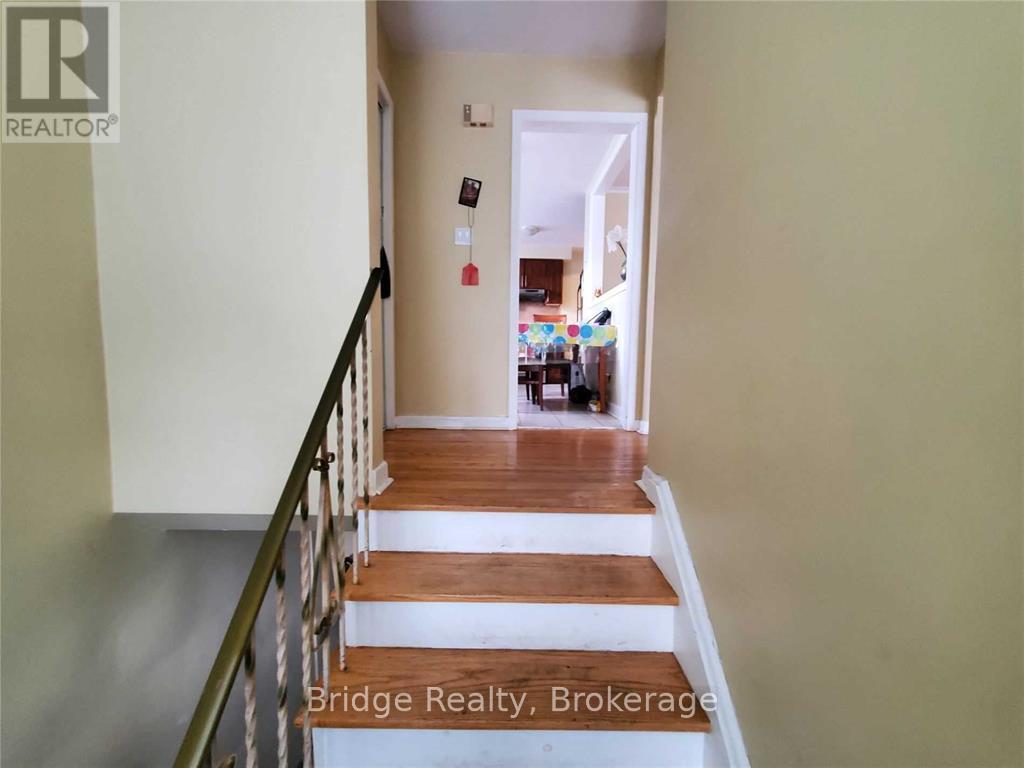 A hallway with a staircase leading to a living room.