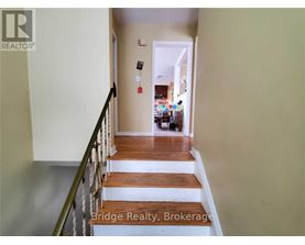 A hallway with a staircase leading to a living room.