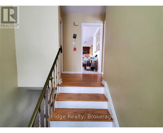 A hallway with a staircase leading to a living room.