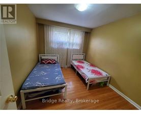 A bedroom with two beds and a window with curtains.