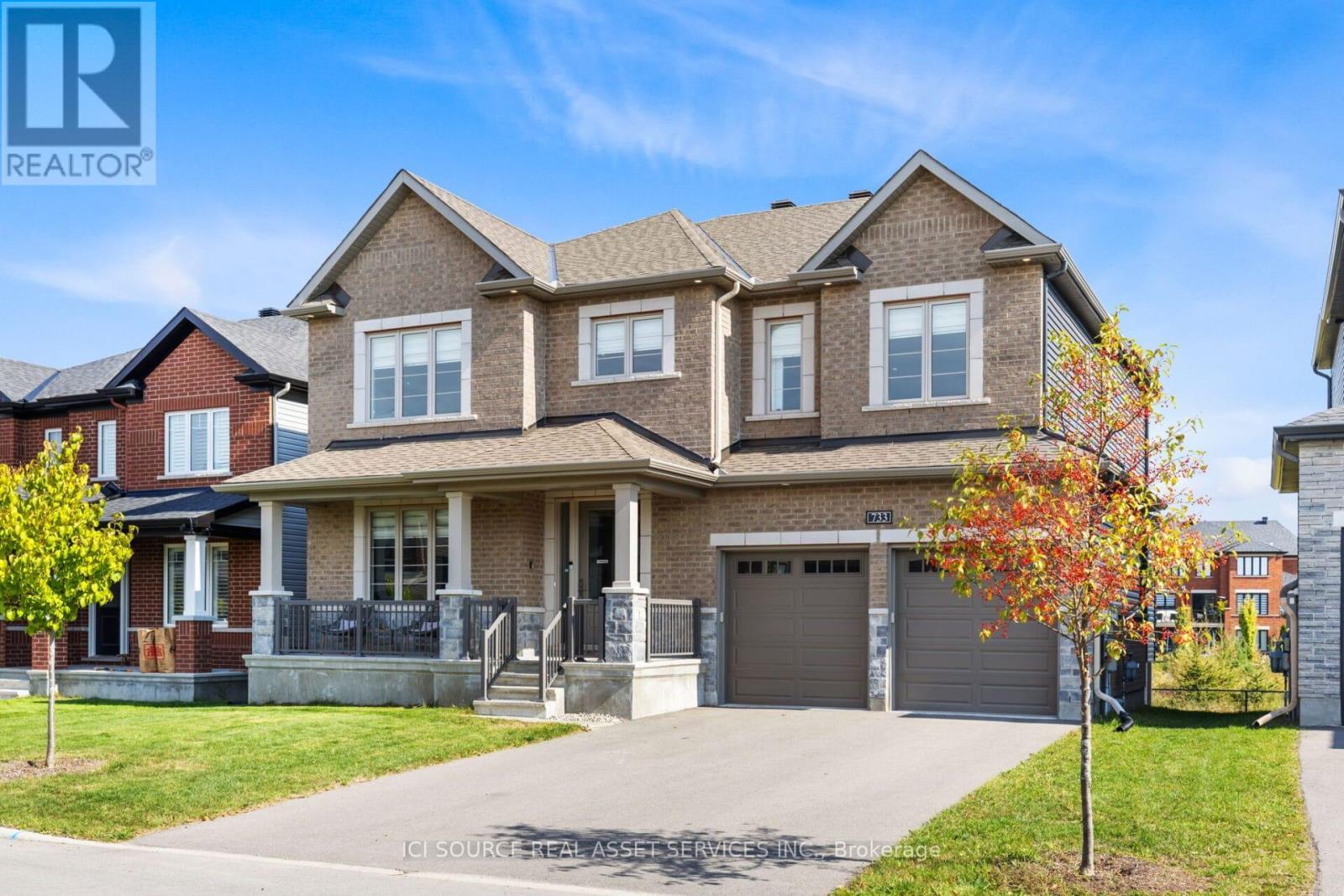 A large, well-maintained house with a brick facade and multiple garages.