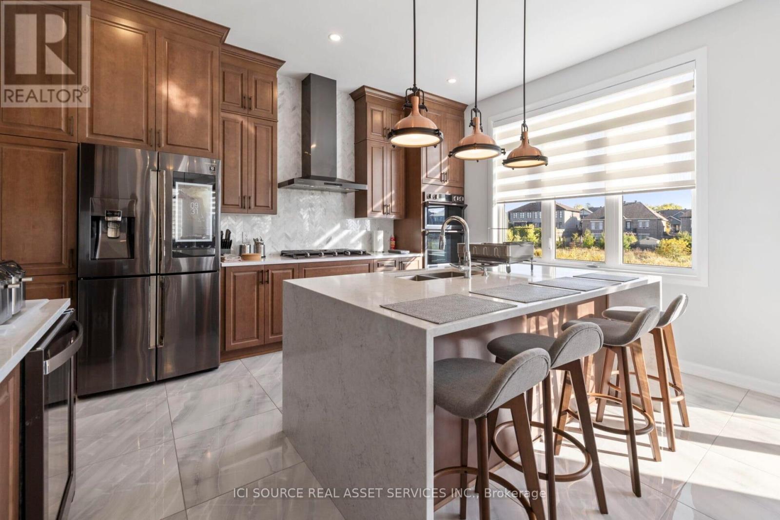 A modern kitchen with a large island and stainless steel appliances.