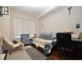 A bedroom with a bed, chair, and desk.