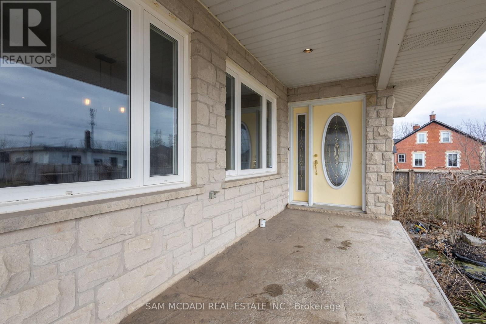 A real estate company's sign is on the window of a house.