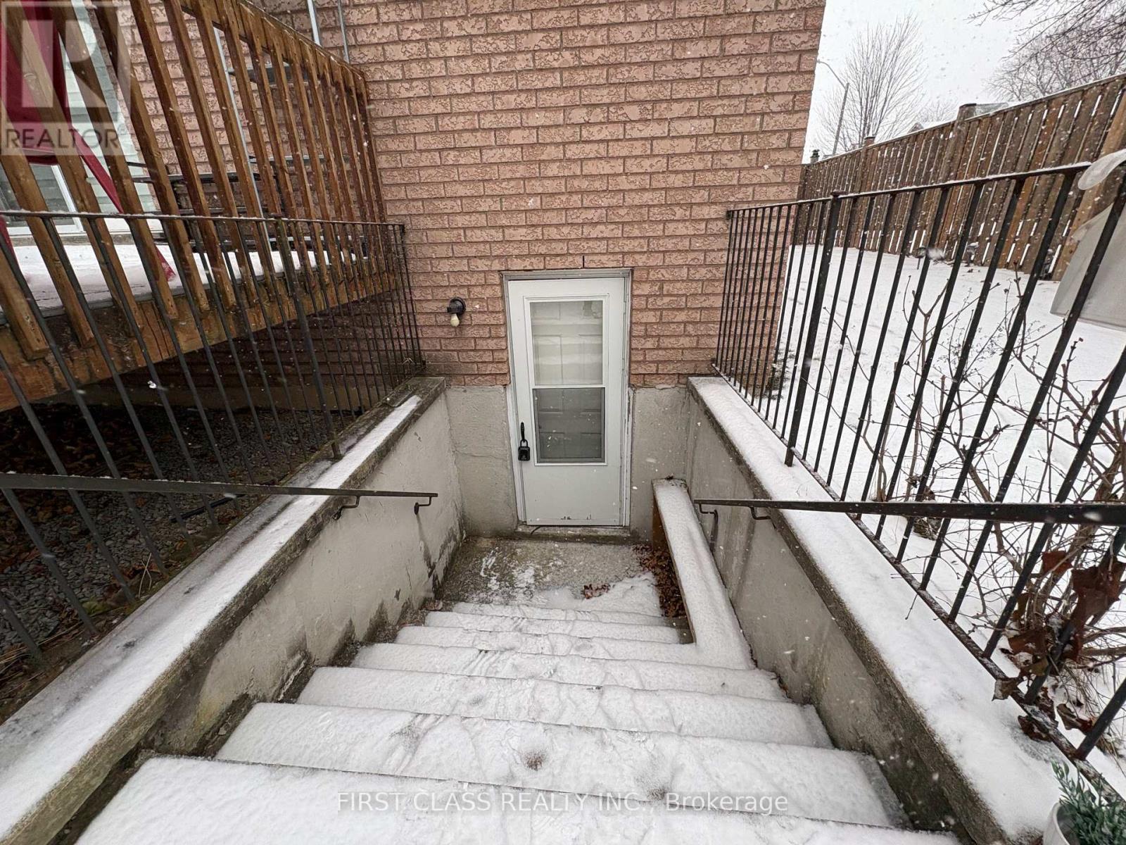 A snow-covered staircase leads to a white door.