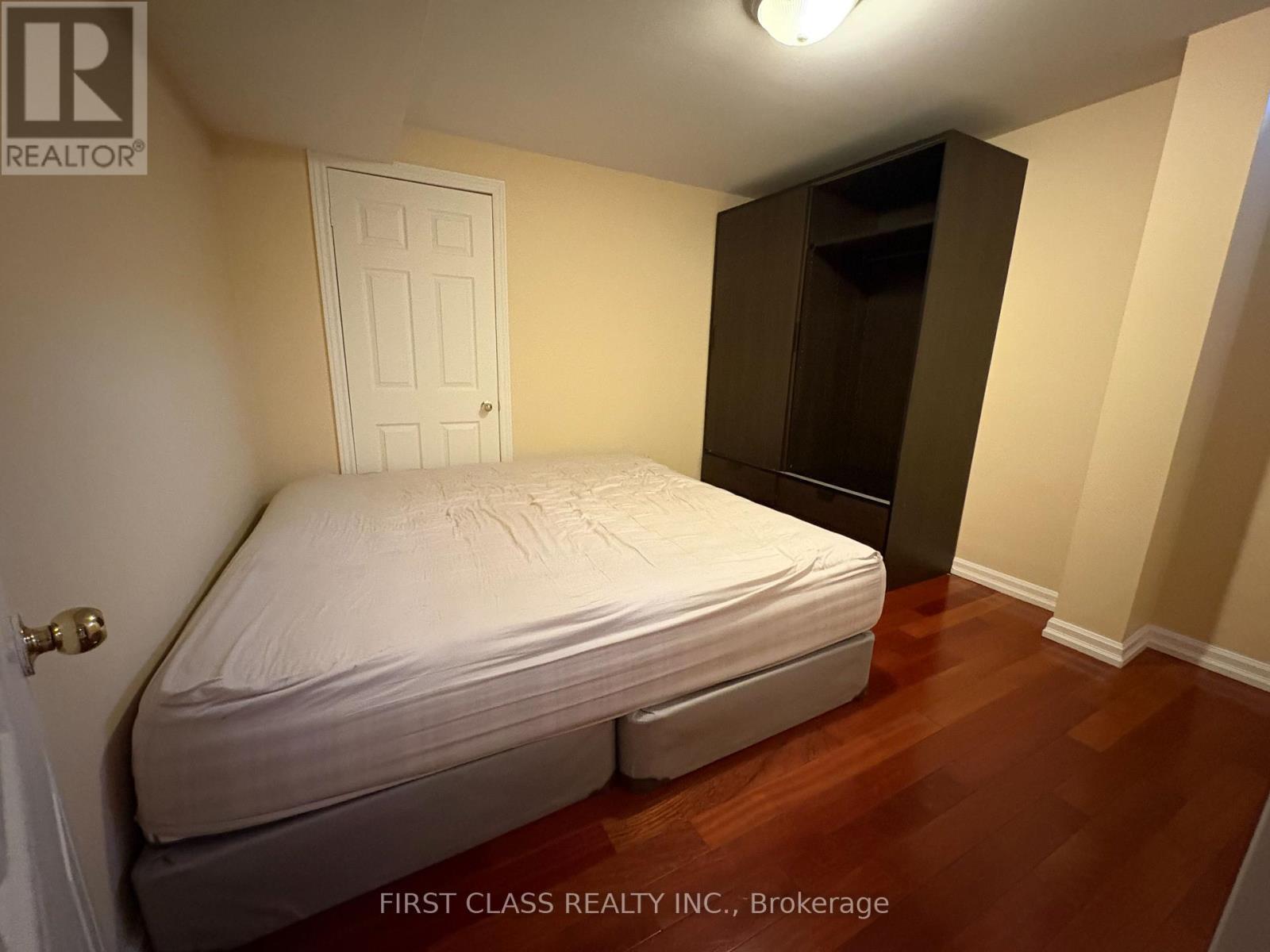 A bedroom with a bed, wardrobe and a door.
