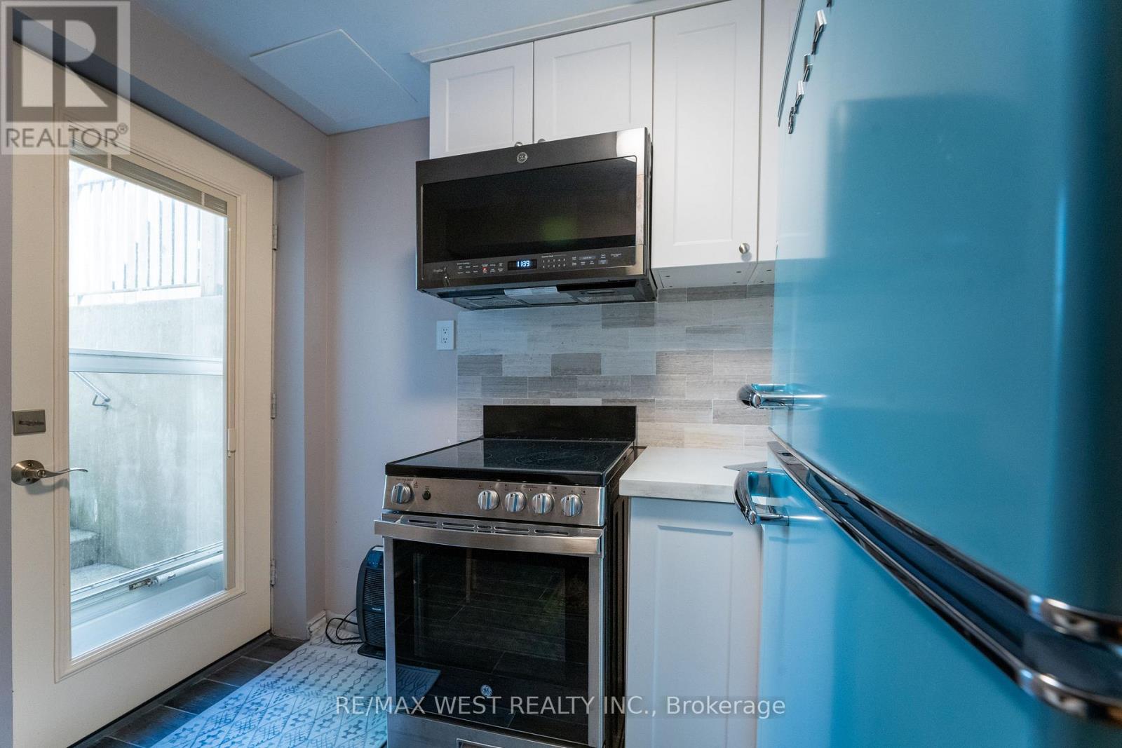 A kitchen with a stove and a microwave above it.