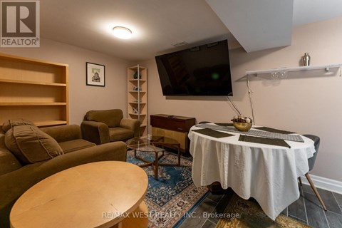 A living room with a couch, chair, and a television mounted on the wall.