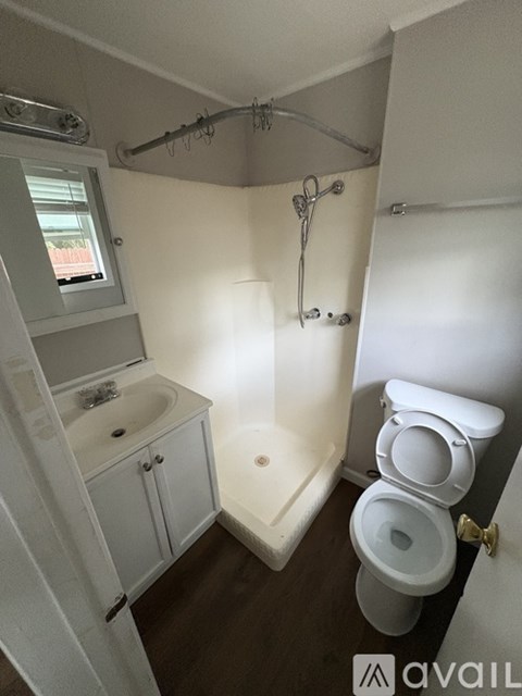 A small bathroom with a toilet, sink, and cabinet.