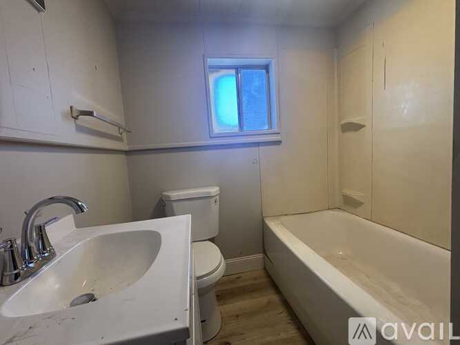 A bathroom with a toilet, sink, and bathtub.
