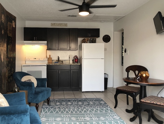 A kitchen with a white fridge and a ceiling fan.