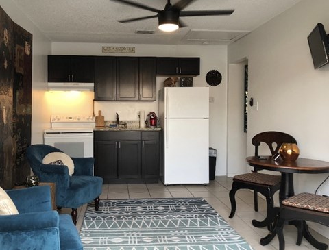 A kitchen with a white fridge and a ceiling fan.