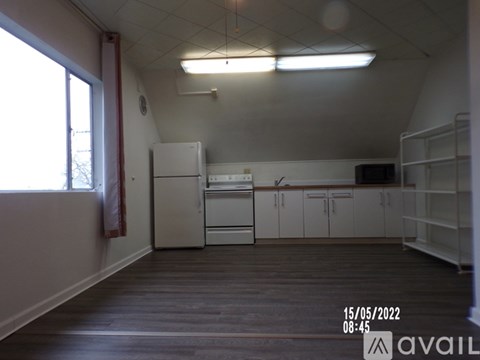 A kitchen with white appliances and cabinets is available for rent.