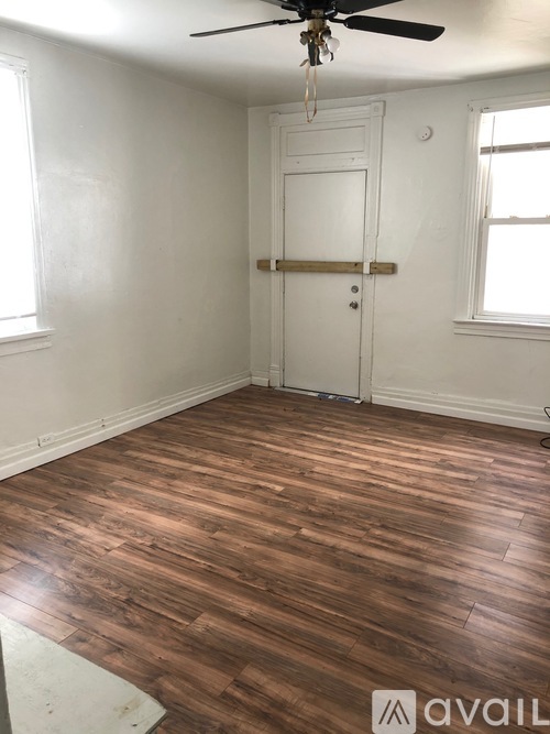 A room with a wooden floor and a white door.