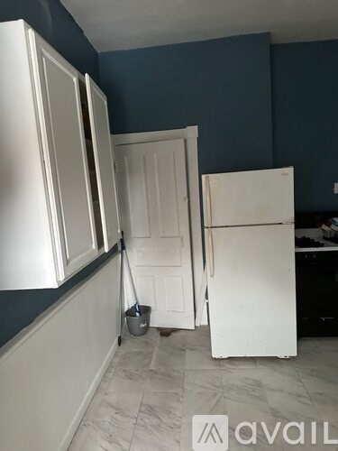 A kitchen with white cabinets and a white fridge.