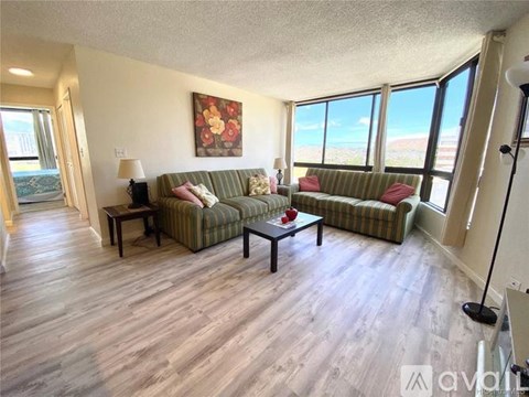 A living room with a couch, a coffee table, and a painting on the wall.
