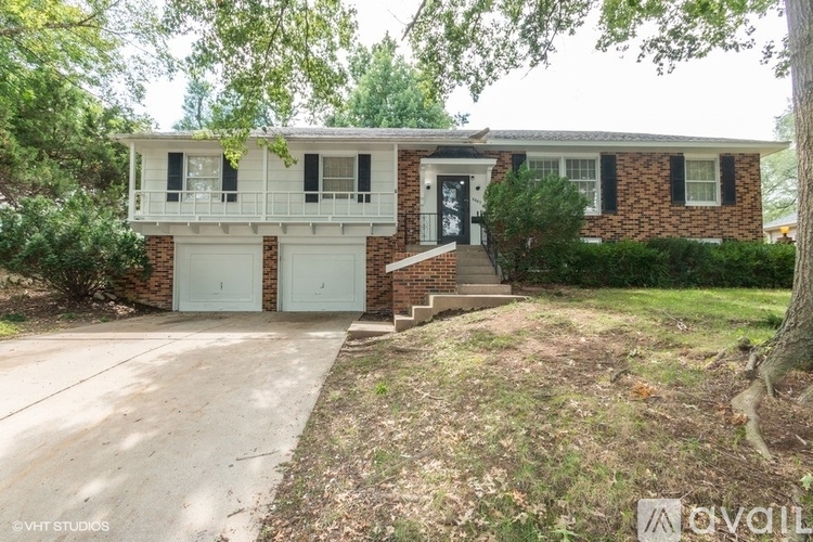 A house with a white garage door is surrounded by trees.