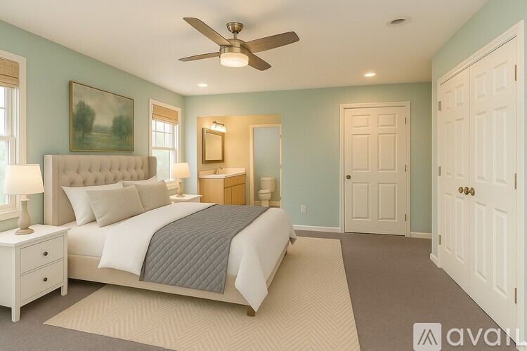 A bedroom with a large bed, a ceiling fan, and a painting on the wall.