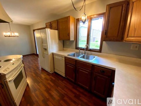 A kitchen with wooden cabinets and a white refrigerator.