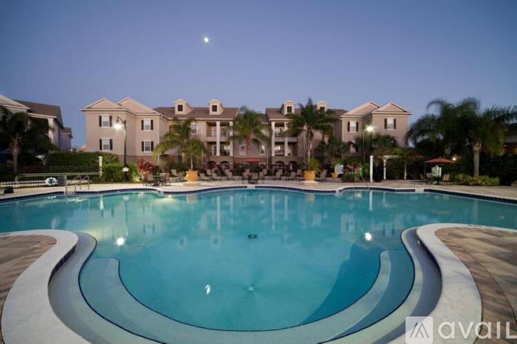 A large swimming pool in front of a building with a moon in the sky.