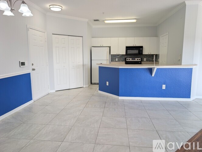 A kitchen with blue walls and white cabinets.