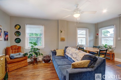 A living room with a blue couch and a wooden floor.