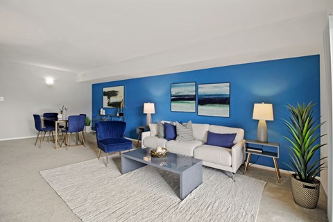 a living room with a blue accent wall and a white couch