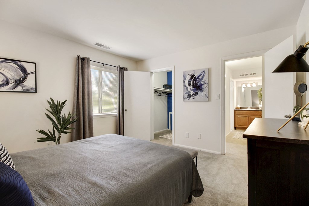 a bedroom with a bed and a view of a bathroom and a closet