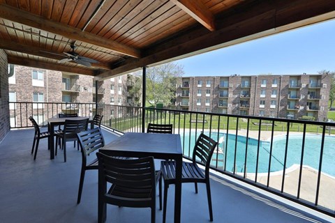 a patio with a table and chairs overlooking a swimming pool