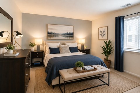 A bedroom with a large bed, a bench, and a painting on the wall.