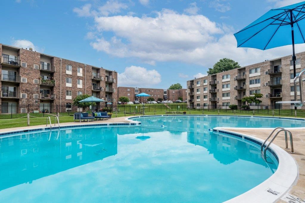 a swimming pool with an apartment building in the background