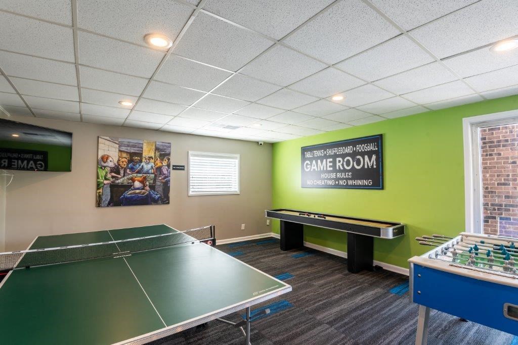 a game room with two ping pong tables and a pool table