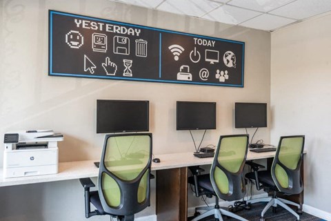 a conference room with three desks and chairs and a blackboard