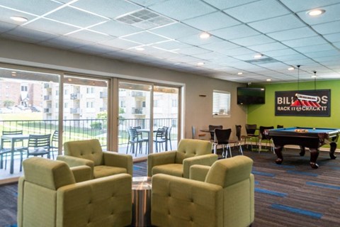 a game room with a pool table and chairs