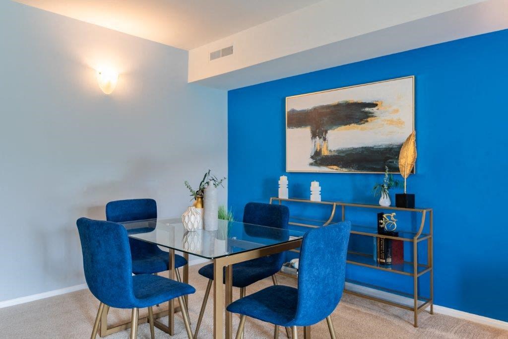 a dining room with blue walls and a table and chairs