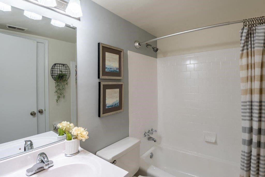 a bathroom with a sink and a tub and a mirror