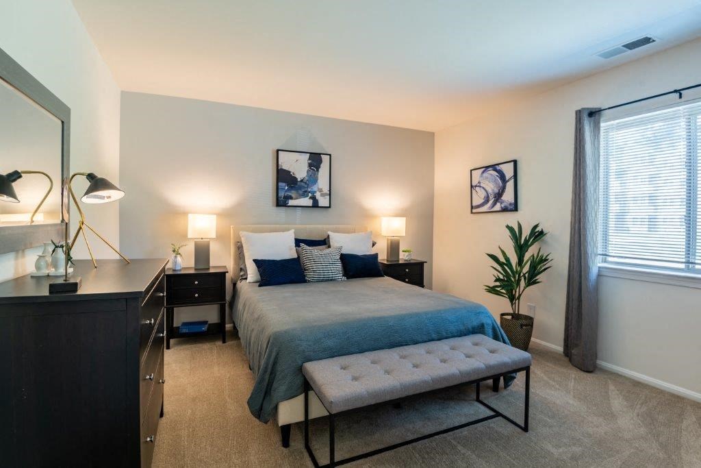 a bedroom with a bed and a dresser and a window