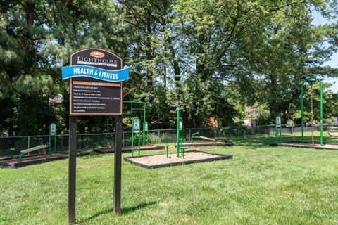 a park with a sign in the grass
