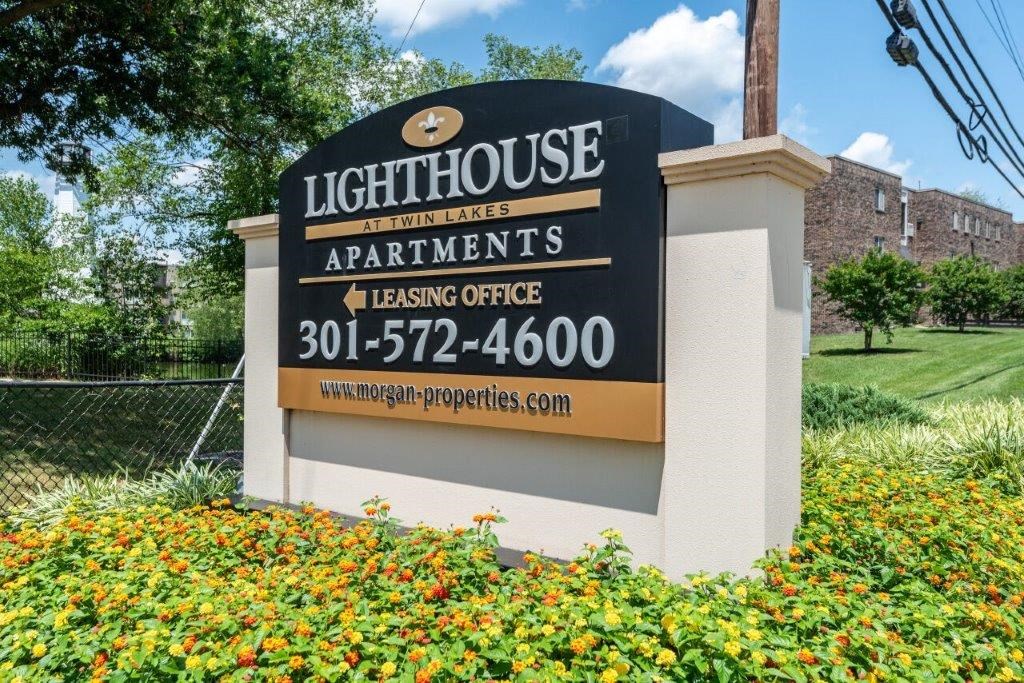 a sign for the light house apartments on the side of a building