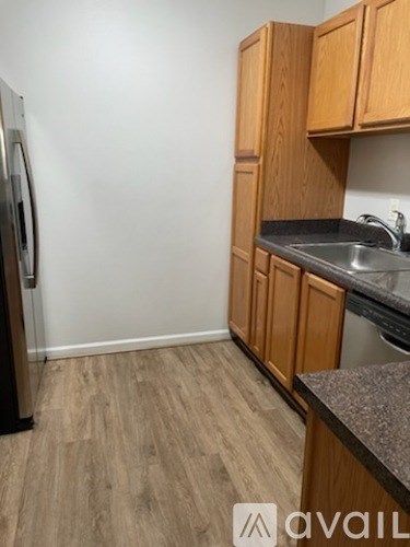 A kitchen with wooden cabinets and a granite countertop.