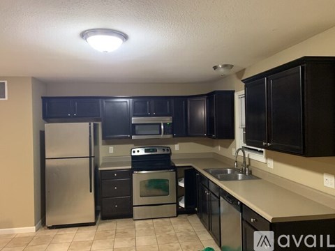 A kitchen with black cabinets and stainless steel appliances.