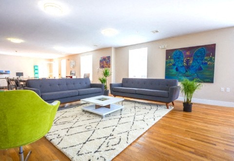 a living room with two blue couches and a table