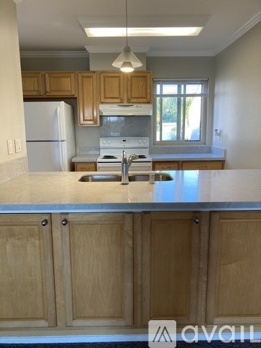 A kitchen with wooden cabinets and a white fridge.